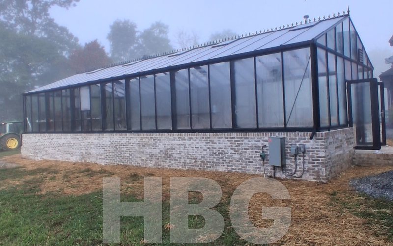 Side view of a Janssens Gigant greenhouse on a brick knee wall in Loudoun County, VA